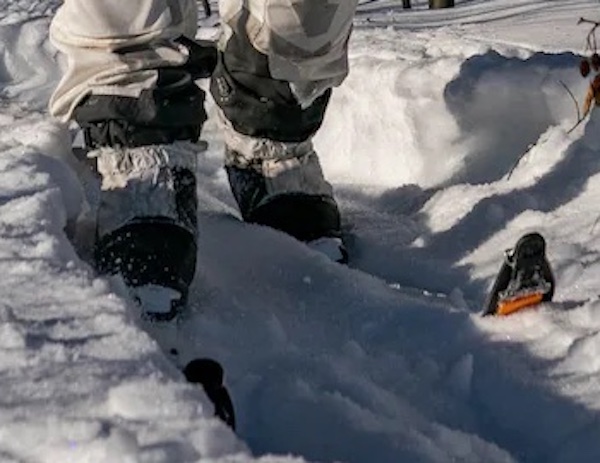 Close-up of soldier on skis showing binding, that other heel is lifted, and ski tips
